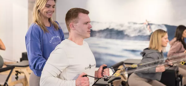 Pilates Teilnehmer mit Trainerin