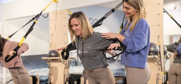 Pilates-Trainerin mit Teilnehmerin am TRX